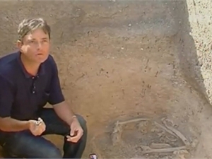 Археолог Вячеслав Масякин показывает римскую бусину, найденную при раскопках. Скриншот с видео ТК «Интер»