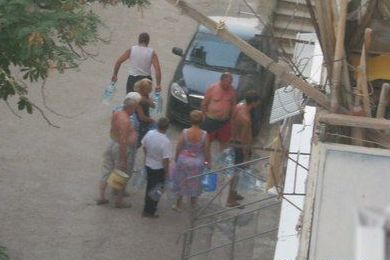Вместо отдыха на пляже курортники занимают очередь за водой. Фото с сайта sandro.in.ua.